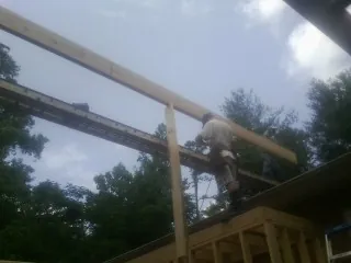 Carpenter setting a ridge beam over a new addition frame — Ice Dam Removal by Roofing Brothers in Toms River