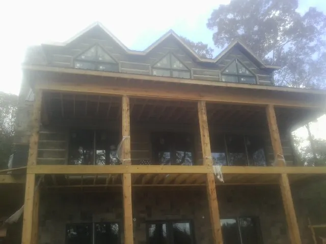 Dormers and porch framing on a large log home under construction — Roof Coating work by our crew in Toms River